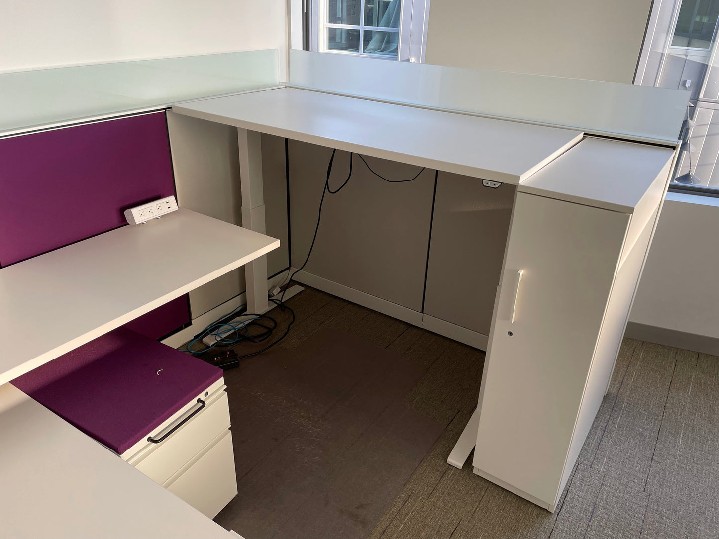 Picture of Herman miller canvas cubicle system with white and purple panels and sit stand desk